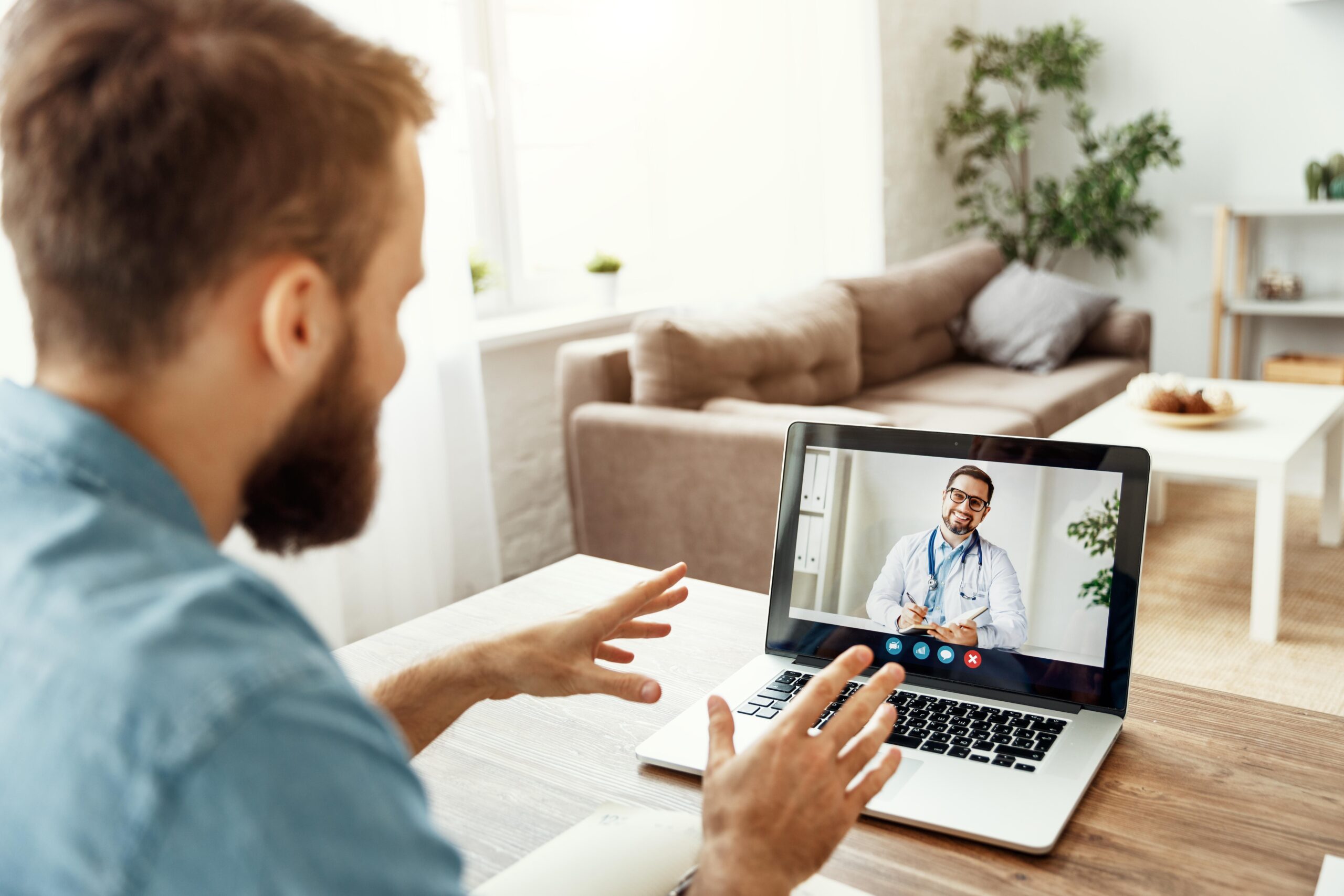 young-man-conducts-video-conference-video-chat-consultation-with-doctor-online-sitting-home